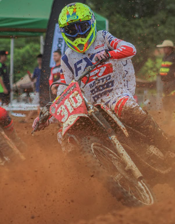 Piloto da Nego Motos conduzindo em terreno de terra